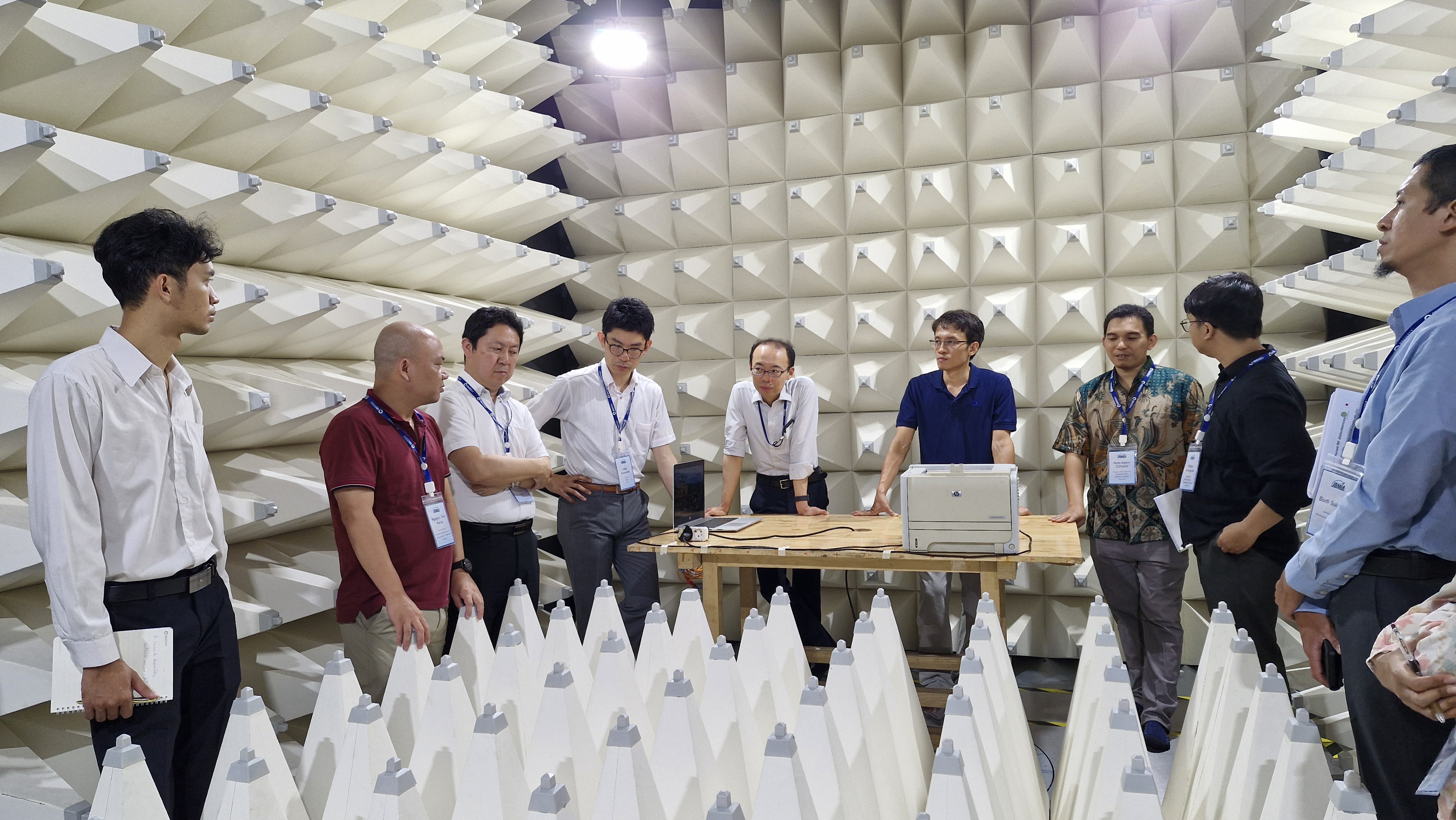 A group of people standing around a tableAI-generated content may be incorrect.